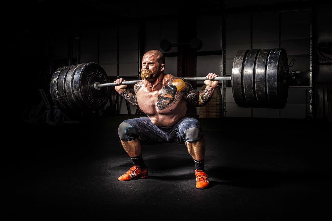 a man with a lot of muscle doing a squat